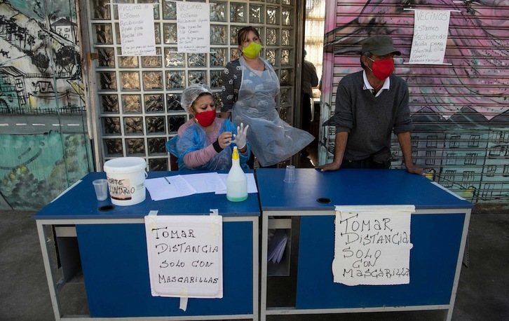 Un grupo de voluntarios se prepara para repartir comida en el barrio de La Pintana, en Santiago. (Martín BERNETTI | AFP)