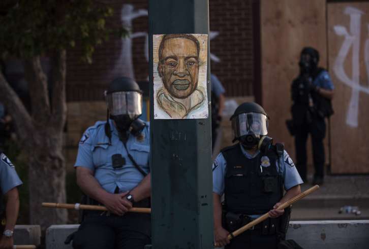 Dos policías rodean en Minneapolis retrato pintado a mano de George Floyd   (Stephen MATUREN I AFP)
