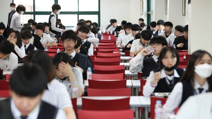 Estudiantes guardan las medidas de distanciamiento mientras almuerza en clase en una escuela de secundaria de Seúl. (YONHAP | AFP)