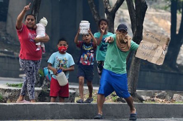 Una familia pide dinero en una calle de Tegucigalpa. (Orlando SIERRA/AFP)