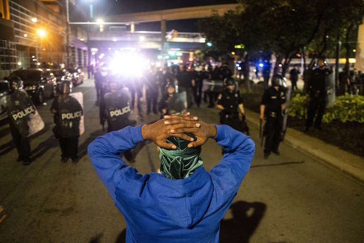 Un hombre levanta las manos ante un cordón policial en Detroit. (Matthew HATCHER/AFP)