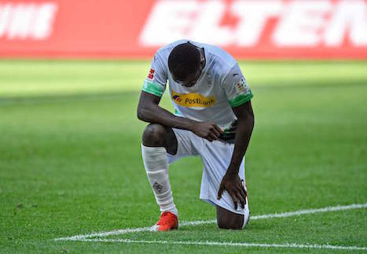 Marcus Thuram se arrodilla y baja la cabeza como forma de protesta ante la muerte de George Floyd. (Martin MEISSNER/AFP)