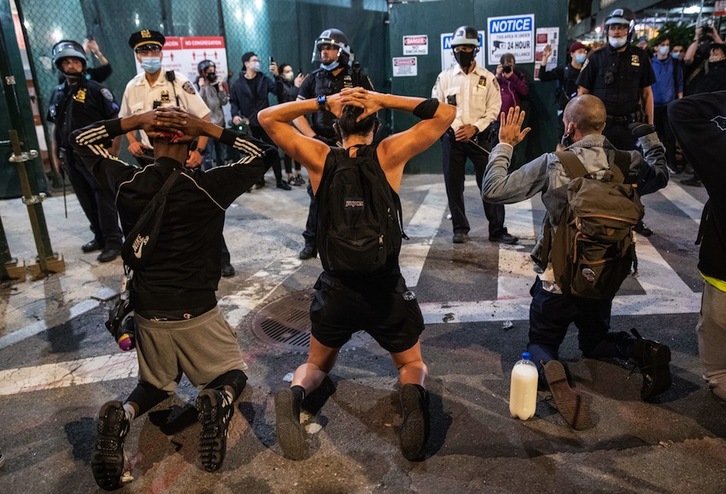 Jóvenes se arrodillan frente a la Policía en Manhatan. (John MOORE/AFP) 