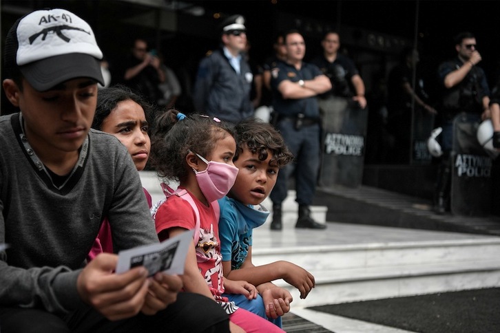 Una familia de refugiados en una protesta contra las expulsiones en Atenas. (Louisa GOULIAMAKI | AFP)