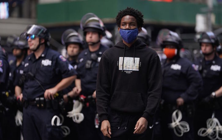 Un joven ante policías desplegados en Nueva York durante las protestas. (Timothy A. CLAIRY/AFP)