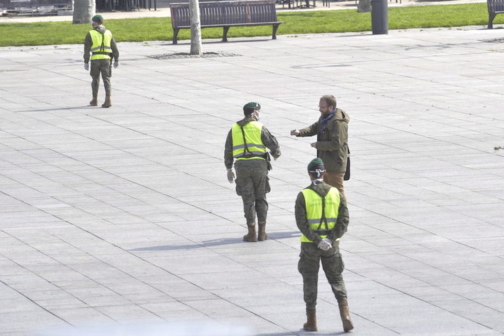 Un hombre presenta un documento identificativo a un militar en la Plaza del Castillo durante el confinamiento. (Idoia ZABALETA/FOKU)