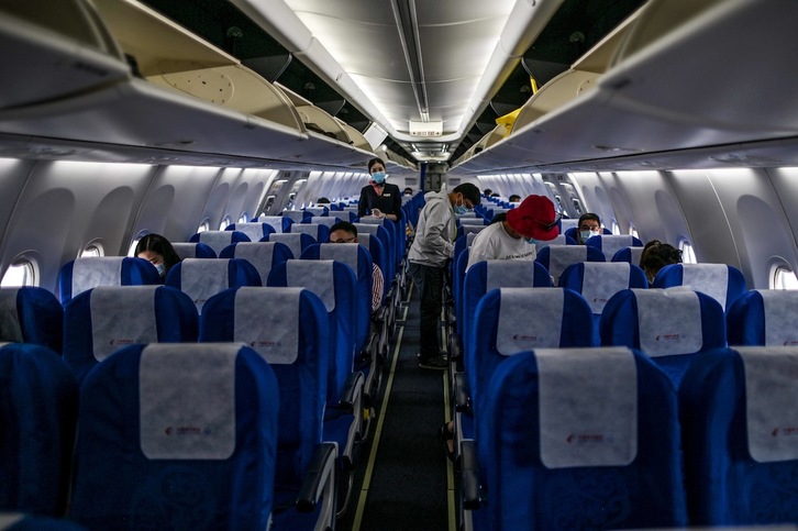 Pasajeros de un vuelo entre Wuhan y Shanghai que partió del aeropuerto Tianhe el 29 de mayo. (Hector RETAMAL | AFP)