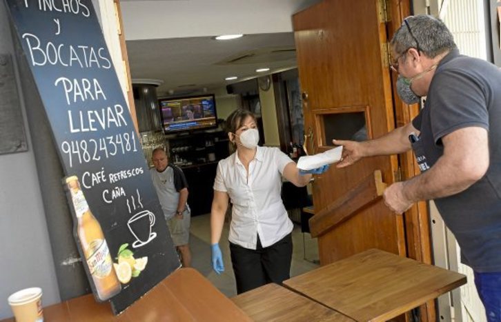 La imagen que abre este reportaje está tomada en Iruñea: venta de bocadillos en el bar Ksual con el debate del Congreso español en televisión. Iñigo Uriz | FOKU