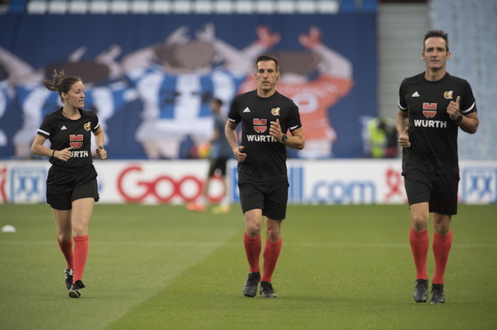 Estrada Fernández, en el centro, calienta con un trío arbitral que no será recordado solo por tener a la primera juez asistente en un partido en Anoeta. (Juan Carlos RUIZ/FOKU)