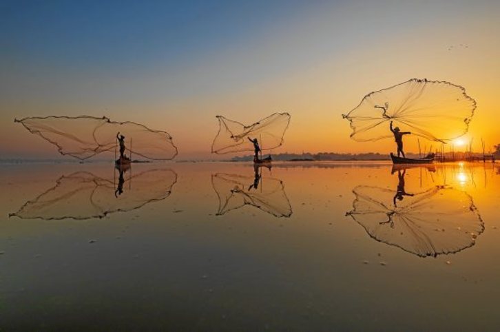  Bajo el significativo título de «Trae a casa la cosecha», tres pescadores birmanos lanzan sus redes en un lago cercano al puente U Bein en Mandalay (Myanmar). Fotografía: Zay Yar Lin|Pink 