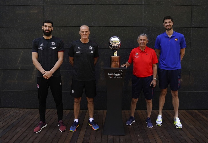 Los capitanes y entrenadores del Baskonia y el Barça, rodeando el oscuro objeto del deseo, que es este trofeo que acredita el título de la Liga ACB 2019/2020. (M. POZO / ACB PHOTO)