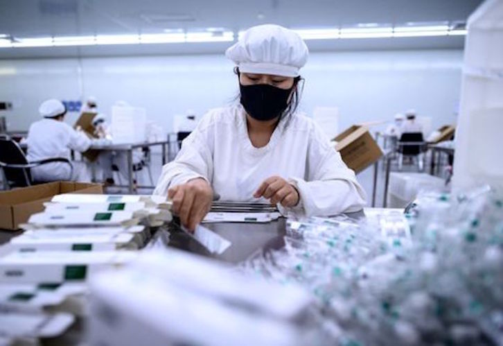 Una trabajadora empaqueta vacunas en un laboratorio chino. (Noel CELIS/AFP)