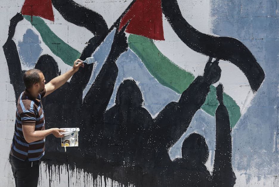 Israelek Zisjordania bereganatzeko planaren kontrako mural bat margotu dute Gazan. (Said KHATIB/AFP)