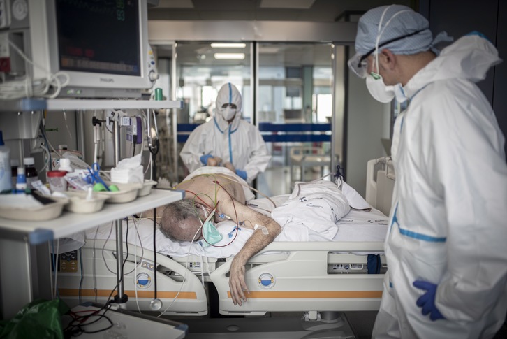 Un fisioterapeuta trata a un enfermo de Covid-19 en la sección de reanimación del hospital de Cruces. (Andoni LUBAKI/FOKU)