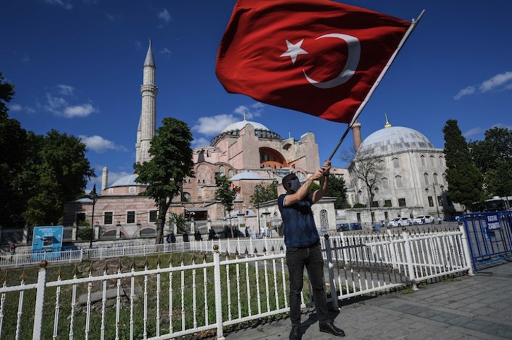 Un hombre ondea una bandera turca ante Santa Sofía. (Ozan KOSE / AFP)