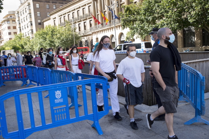 Personas con mascarilla pasan por un filtro de acceso a la Plaza del Castillo, el pasado día 6. (Iñigo URIZ/FOKU)