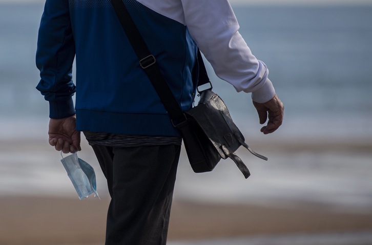 En el paseo marítimo de Zarautz con la mascarilla en la mano. (Gorka RUBIO/FOKU)