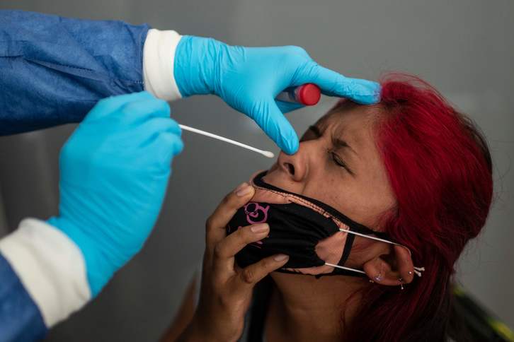 Osasun langile bat, emakume bati PCR test bat egiten, Mexikon. (Pedro PARDO/AFP) 