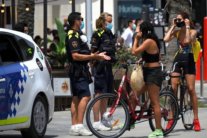 La Policía Municipal controla el uso adecuado de las mascarillas. (Lluis  GENE/AFP)