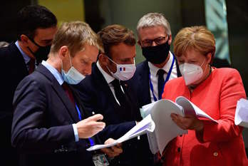 Pedro Sánchez, Emmanuel Macron y Angela Merkel miran el texto del acuerdo. (John THYS-POOL/AFP)