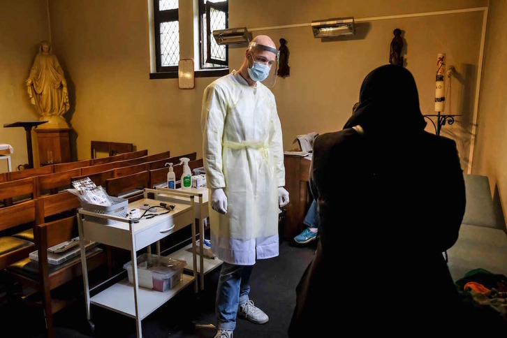Un sanitario de Geneeskunde voor het Volk (Medicina para el Pueblo) atiende a una mujer en Amberes. (Dirk WAEM/AFP)
