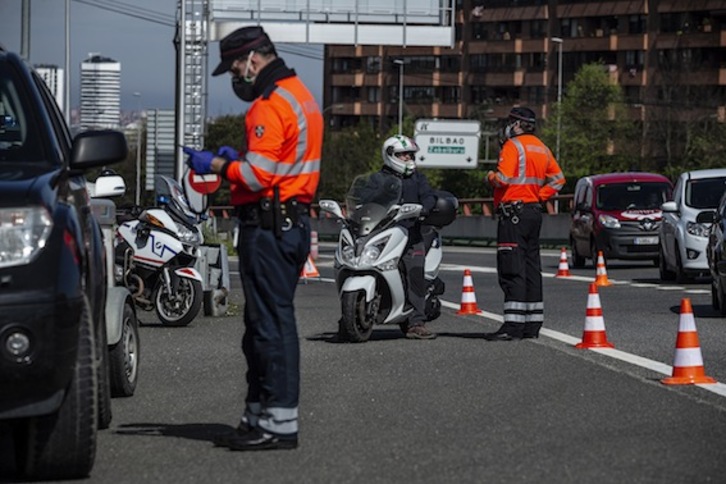 Ertzainas regulan el paso de vehículos en los accesos a Bilbo. (Aritz LOIOLA/FOKU)