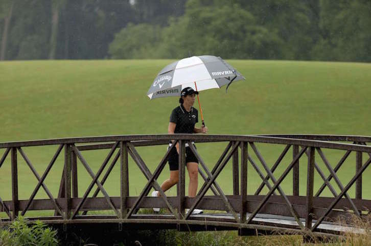 Carlota Ciganda se resguarda de la lluvia durante la jornada del sábado. (Gregory SHAMUS/AFP)