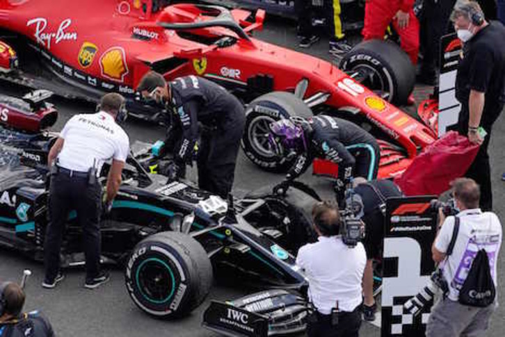 Hamilton inspecciona el neumático delantero izquierdo que ha reventado en la última vuelta. (Will OLIVER/AFP)
