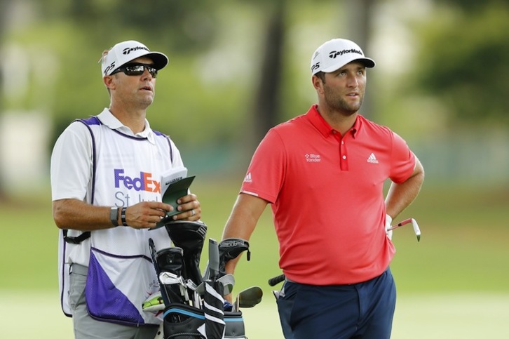 Rahm mira la bola con cara de circunstancias junto a su caddie (Michael REAVES / AFP)