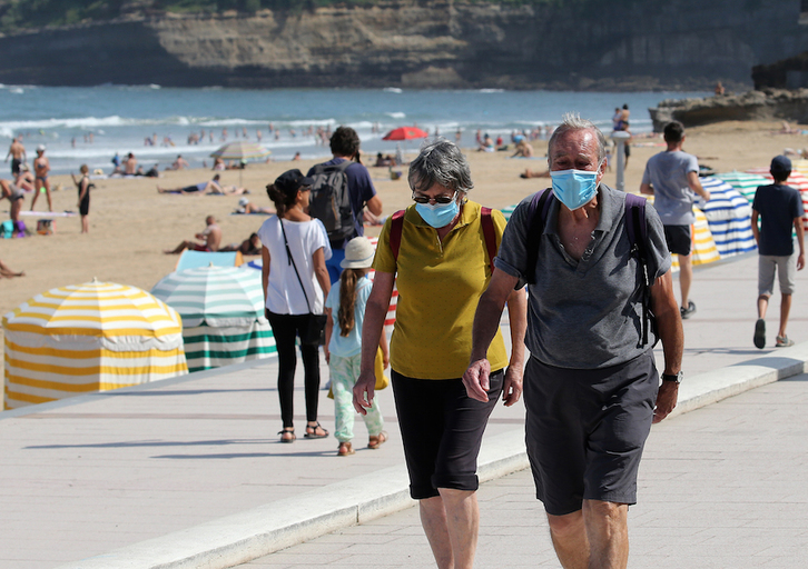 Dos personas con mascarilla junto a la playa de Biarritz. (Bob EDME)
