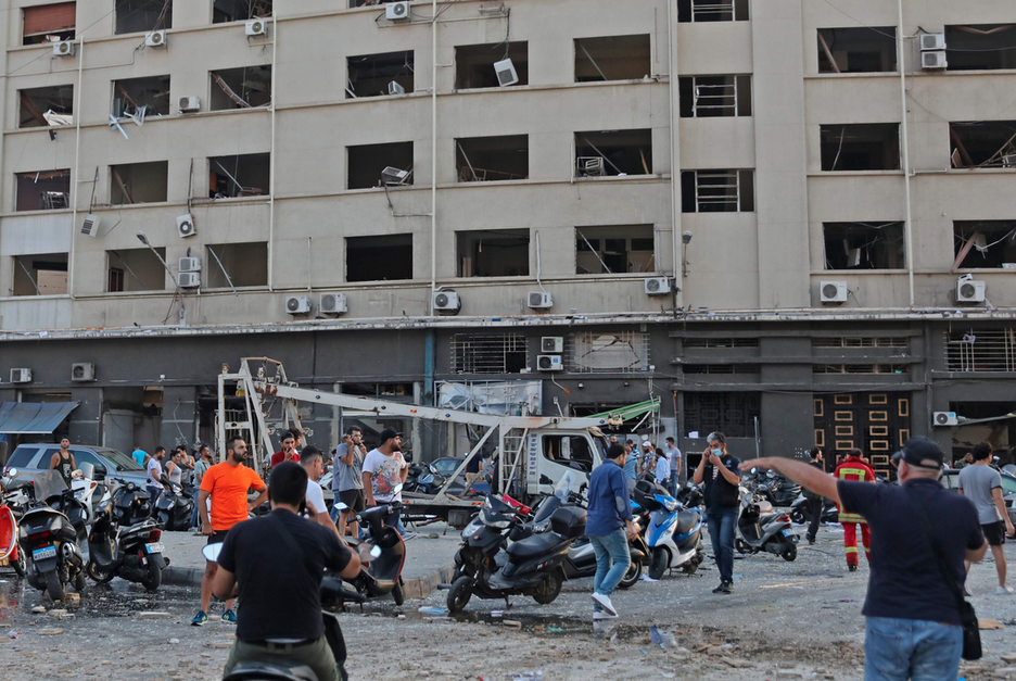 Varias personas en una calle cerca del lugar de la explosión. (Anwar AMRO/AFP).