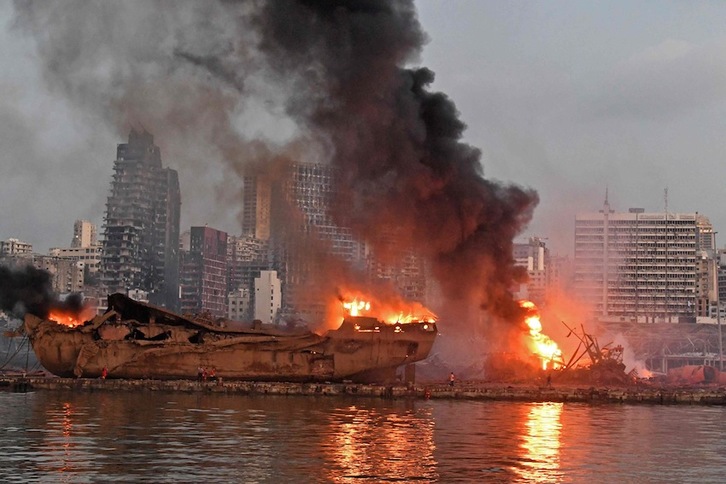 Un buque en llamas, el martes, en el lugar del puerto de Beirut donde se produjo la explosión. (AFP)