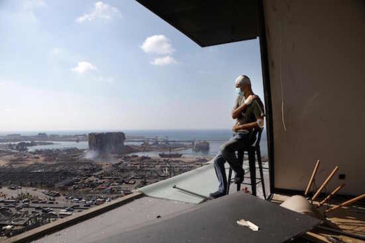 Un hombre mira el estado del puerto de Beirut, devastado tras la explosión. (Patrick BAZ / AFP)