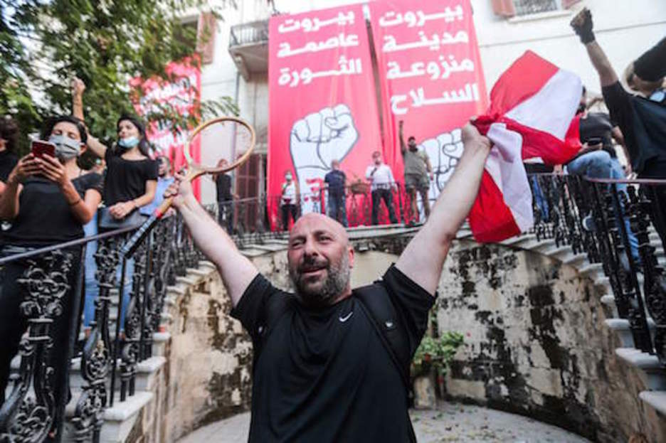 Un manifestante con los brazos en alto en el Ministerio de Exteriores. (AFP)