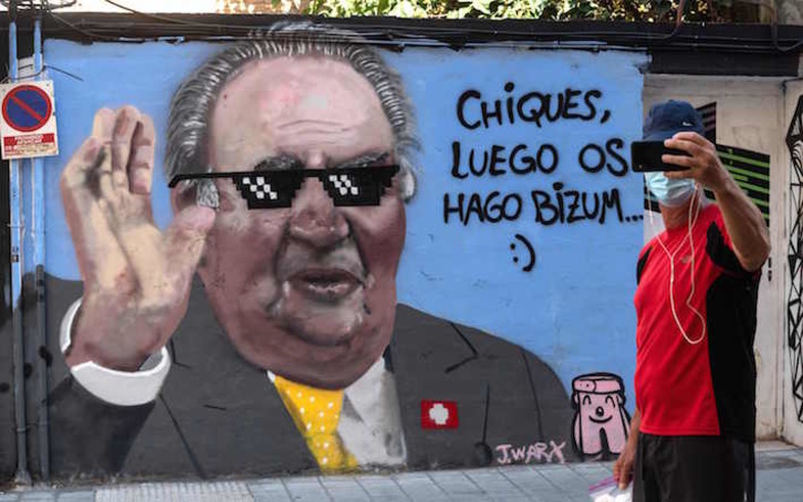 Un hombre se hace un selfie ante un mural sobre la marcha de Juan Carlos de Borbón, en València. (José JORDÁN/AFP) 