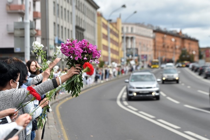 Mujeres protestan desde las aceras con flores por la represión policial. (Sergei GAPON-AFP)