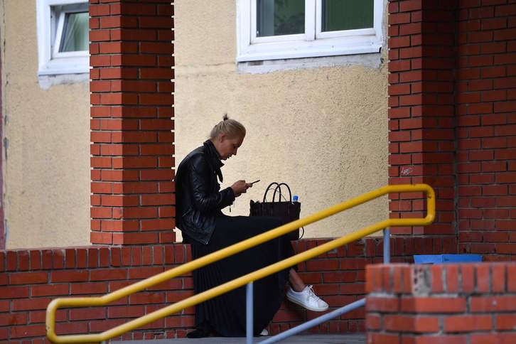 Yulia Navalnaya, mujer de Alexei Navalni, mira su móvil en el exterior del hospital de Omsk. (Dimitar DILKOFF/AFP)