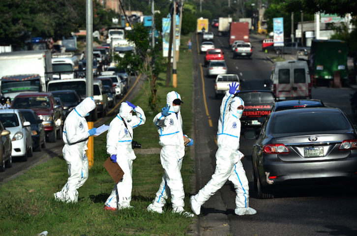 Policías hondureños se dirigen a la escena de un crimen. (Orlando SIERRA/AFP)