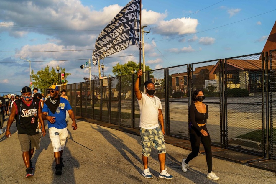 Manifestantes portan una bandera con el lema «Black lives matter» en Kenosha, Wisconsin. (Kerem YUCEL/AFP)