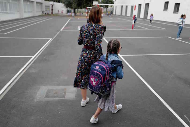 Una madre llega con su hija a un centro educativo de Toulouse. (Lionel BONAVENTURE/AFP)
