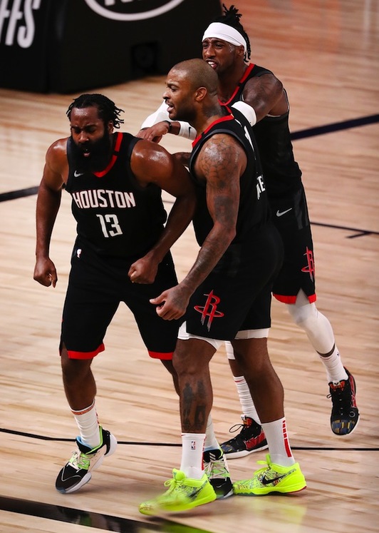 Dos compañeros felicitan a Harden tras su salvador tapón. (Mike EHRMANN / AFP PHOTO)