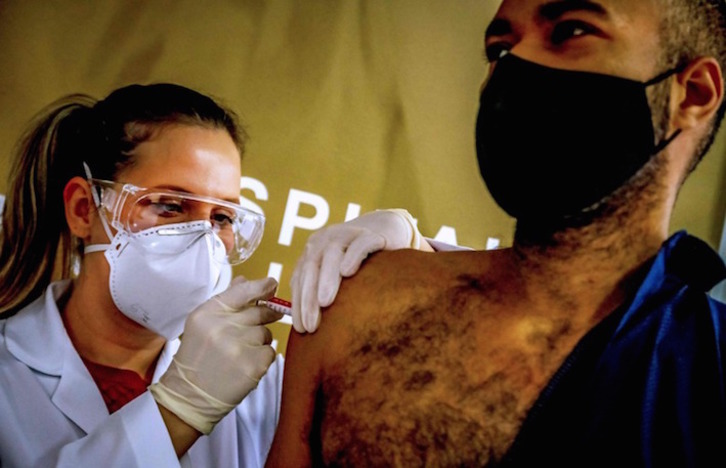 Una profesional sanitaria aplica a un voluntario de Brasil una dosis de la vacuna diseñada por la compañía china Sinovac Biotech. (Silvio AVILA/AFP)