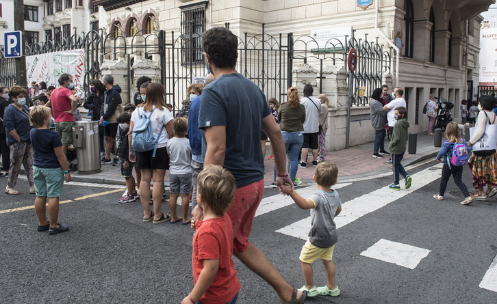 Un padre acompañando a los niños al colegio. (Raúl BOGAKO/FOKU)
