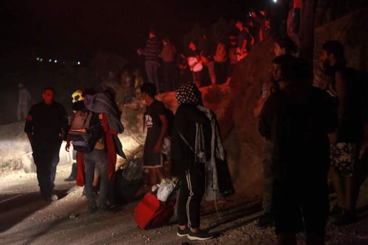 Migrantes y refugiados, en las inmediaciones del devastado campo de Moria. (Manolis LAGOUTARIS/AFP)