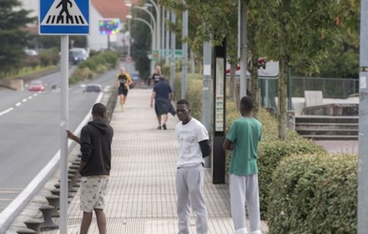 Migrantes esperan en el puente de Santiago, en Irun, a unos metros de la muga con Hendaia. (Gorka RUBIO / FOKU )