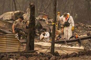 Personal de rescate buscan posibles restos humanos entre los restos calcinados de viviendas en Ashley, Oregon. (David RYDER/AFP)