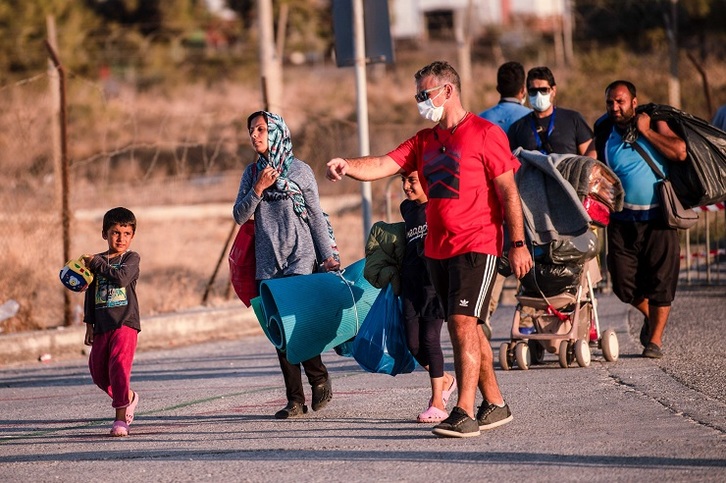 Personas refugiadas en Moria son trasladadas al campamento temporal instalado cerca de Panagiuda. (Angelos TZORTZINIS / AFP)
