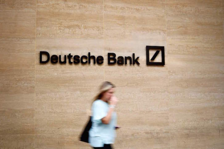 Una mujer pasa junto al logo de Deutsche Bank, uno de los bancos señalados.(Tolga AKMEN/AFP)