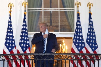 Trump se retira la mascarilla en su vuelta a la Casa Blanca después de salir del hospital. (Win MCNAMEE/AFP)