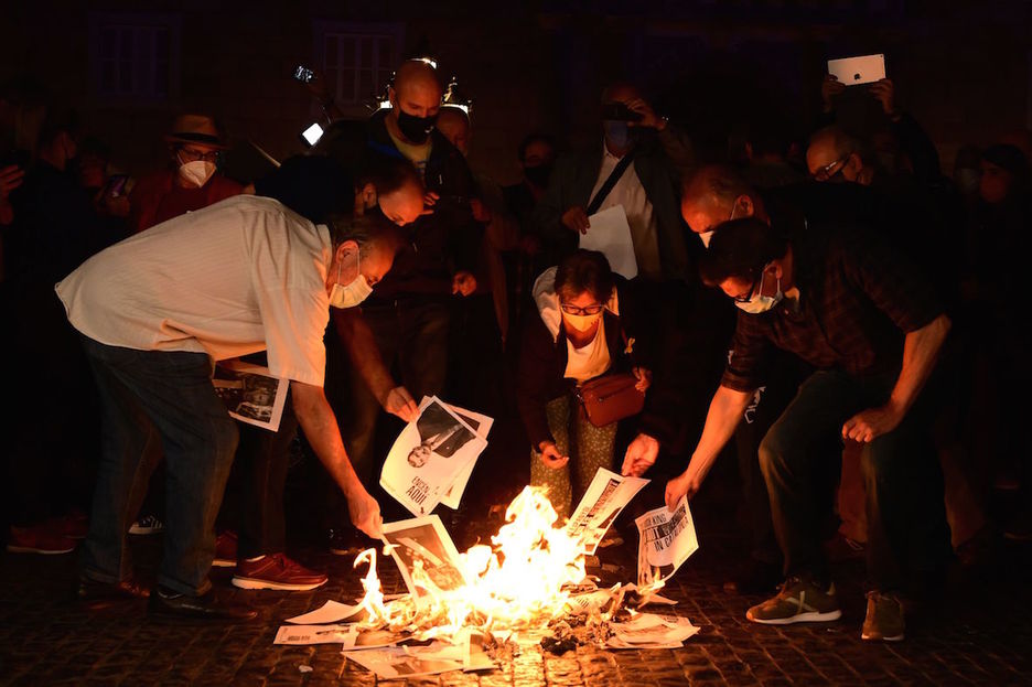 Un grupo de personas quema retratos del rey español en Barcelona. (Lluís GENE/AFP)